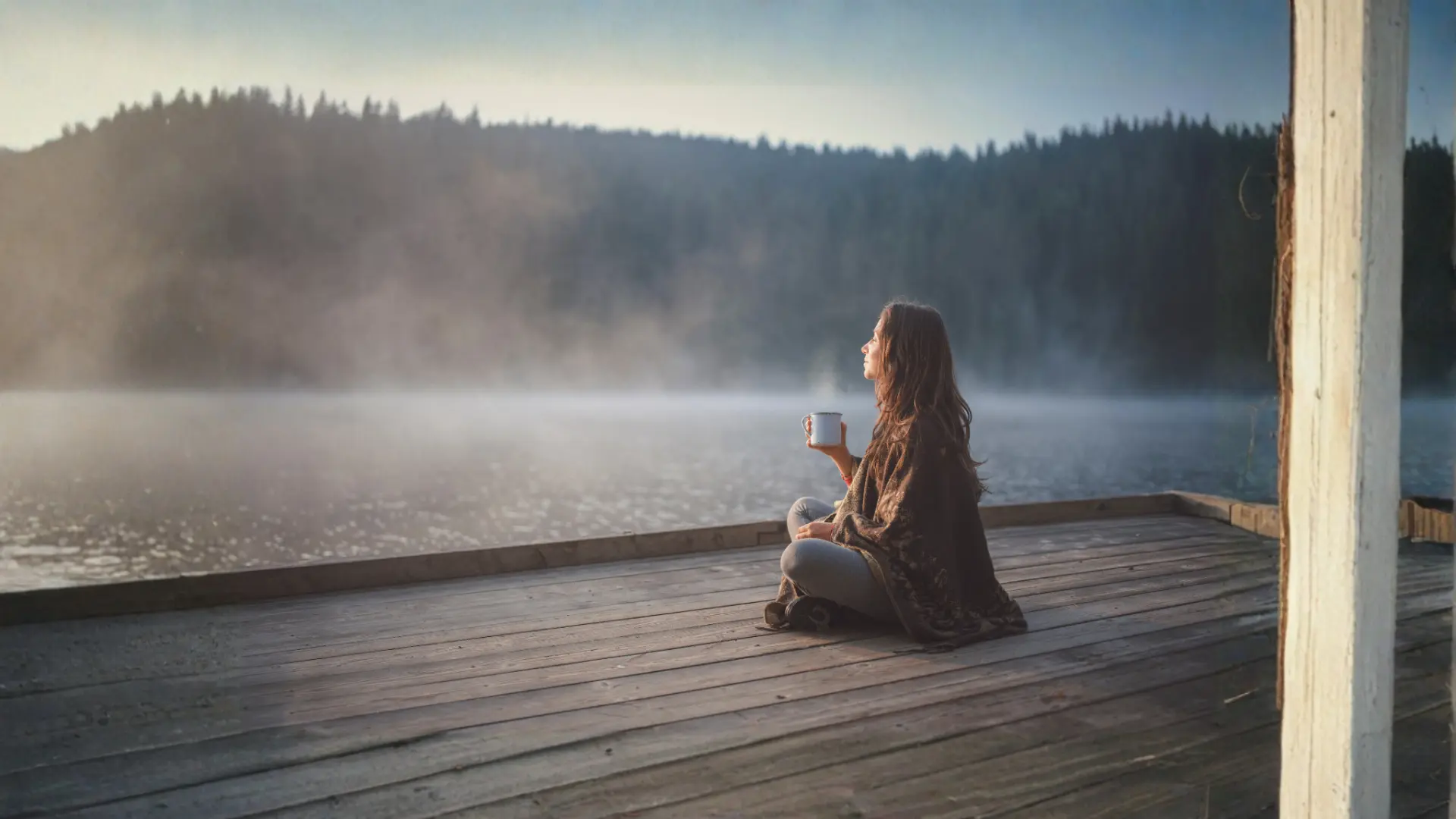Woman enjoying a quiet reflective moment beside a calm lake
