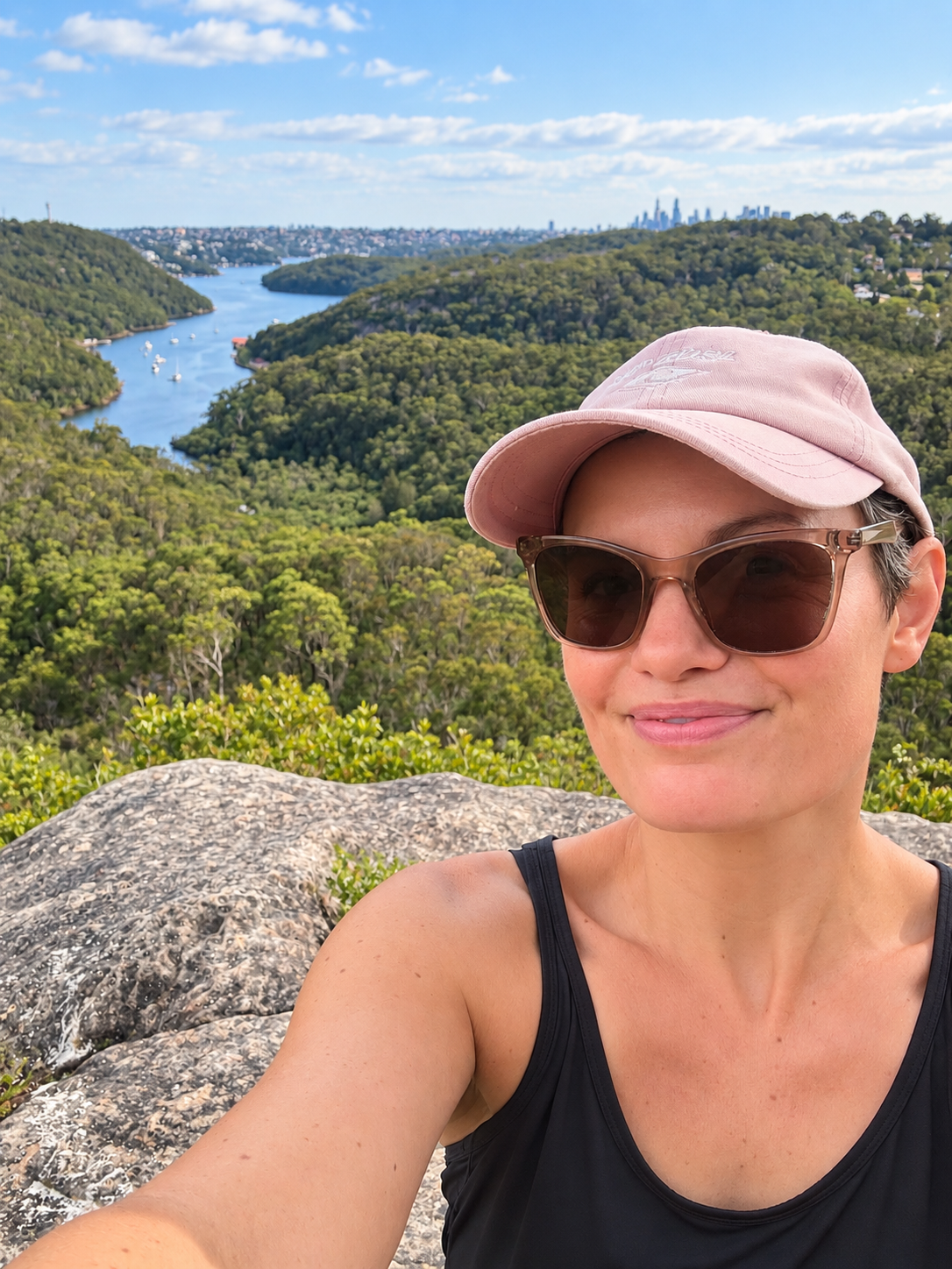 Rina enjoying a clear view across green hills and open water