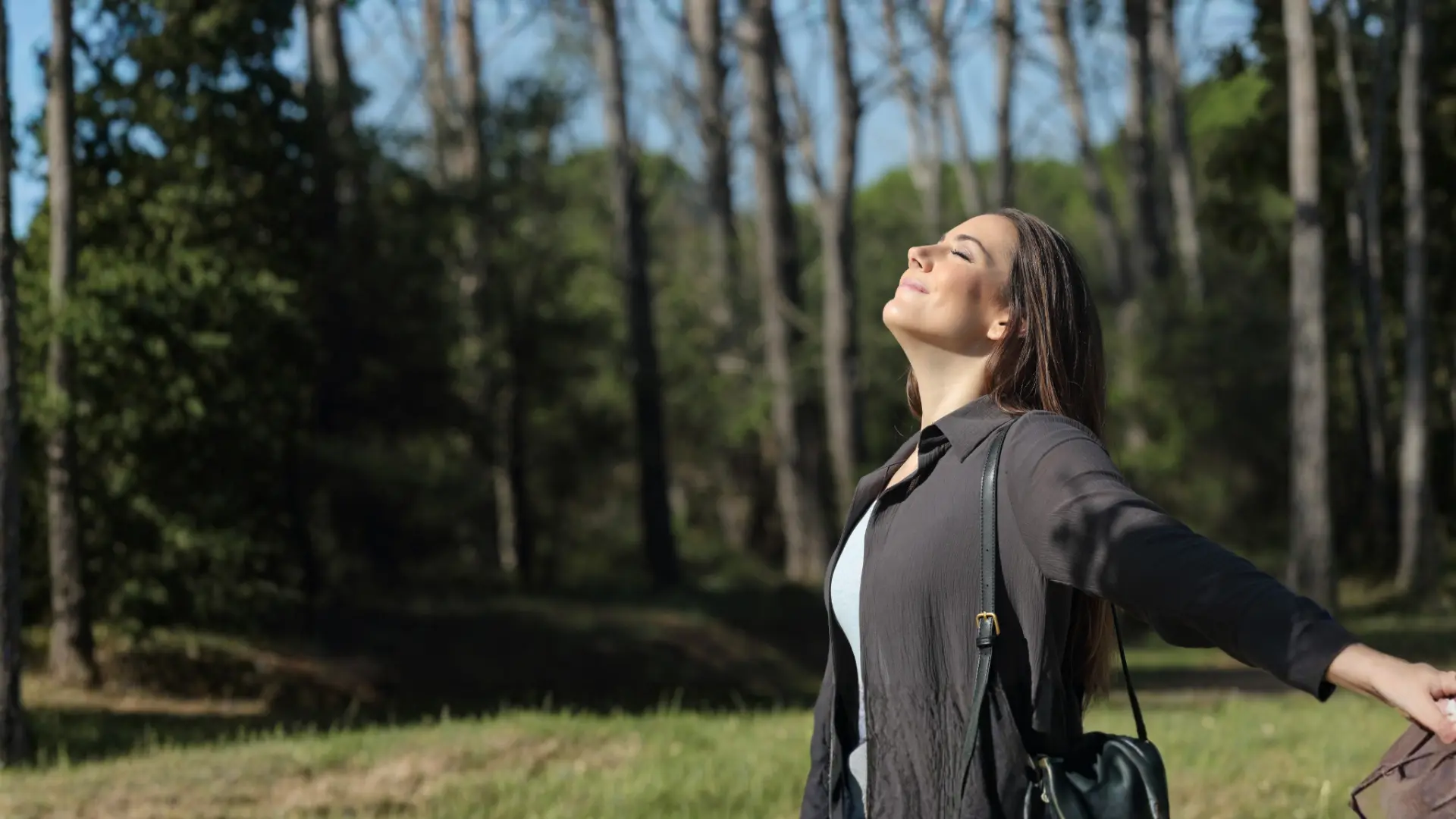Woman pausing in the sunshine with her arms open
